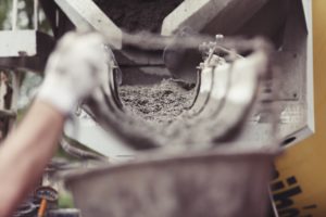 Photo showing mixer pouring concrete. Ready for the workers to disperse. Hand in photo.